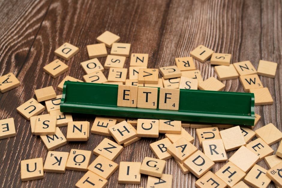 Boring Index Funds Beat Wall Street — Wooden tiles spelling ETF on a game holder, representing investment themes.