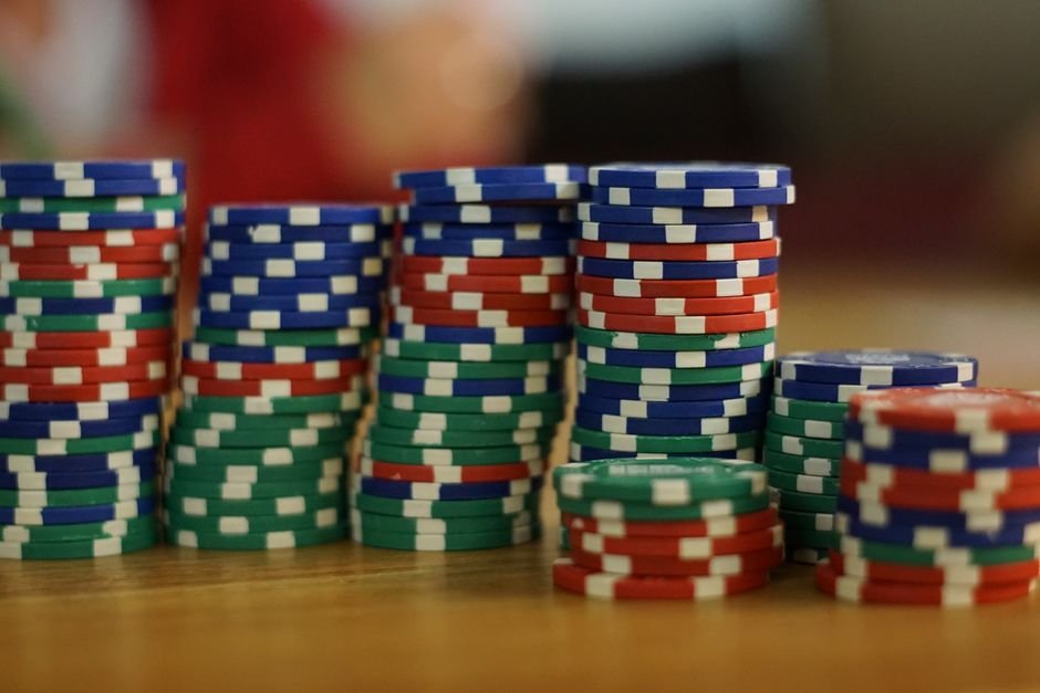 Casinos Engineer Losses Down to the Carpet — A close-up view of colorful stacked poker chips on a wooden table, perfect for c