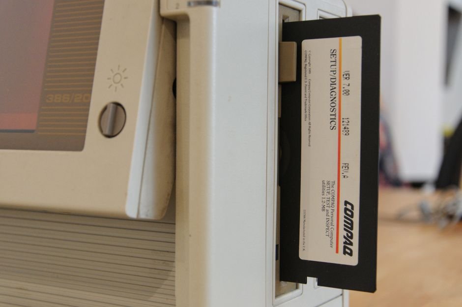 Compaq Fell From Record Growth to Obscurity — Close-up of a vintage computer showing a floppy disk in the drive.