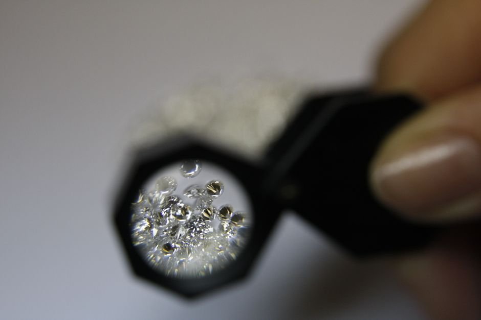 De Beers Engineered Diamond Scarcity — From above closeup of crop anonymous female jeweler with magnifying glass and diamonds
