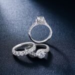 De Beers Engineered Diamond Scarcity — Close-up of luxurious diamond engagement and wedding rings on a textured surface, show