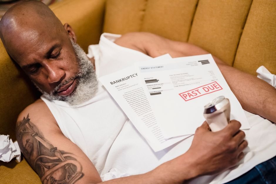 From Bankruptcy to — Sleeping man with financial documents, symbolizing stress and bankruptcy.