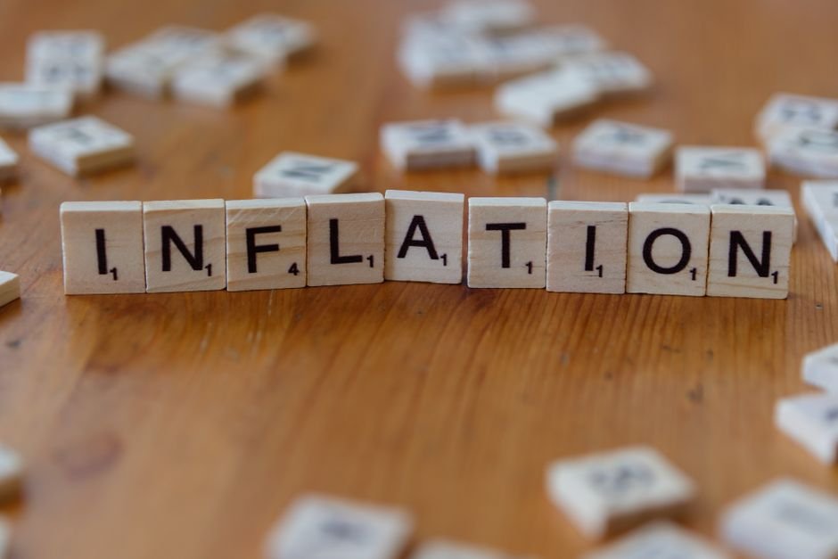 Hidden Power of Compound Interest — Scrabble letter tiles spelling 'INFLATION' on a wooden table, signifying economic concept
