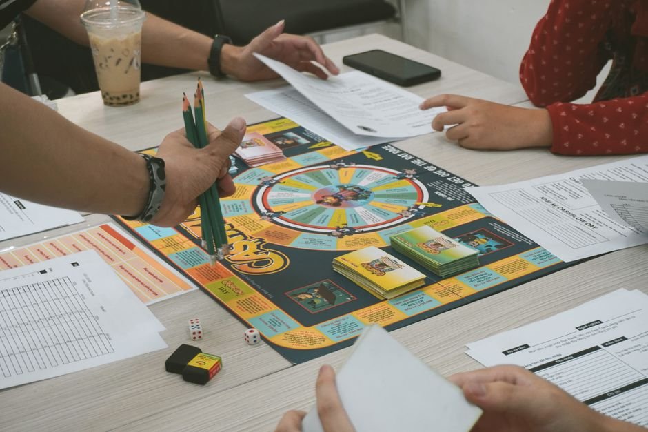 Monopoly — A group of adults playing the Cashflow board game, concentrating on financial planning.