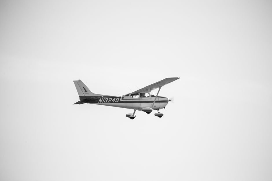 Pan Am Vanished From the Skies — Black and white image of a Cessna Skyhawk airplane flying in clear sky.