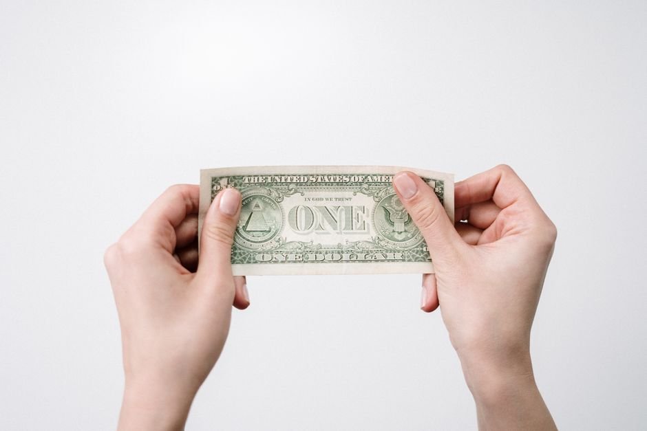 Quiet Power of Dollar‑Cost Averaging — A close-up image of hands holding a one dollar bill, symbolizing finance and economy.