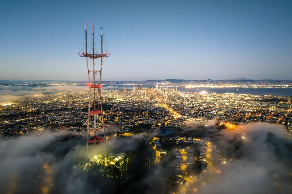 Theranos Tricked Silicon Valley — Aerial view of San Francisco cityscape with Sutro Tower above fog at twilight, showcasing a