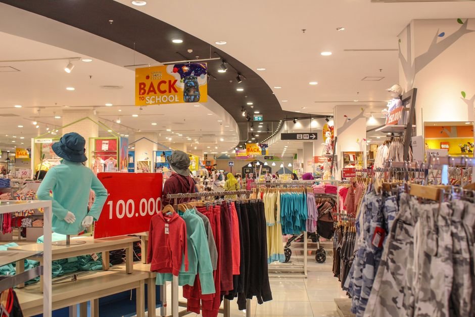 vintage department store retail shopping mall — Lively department store aisle displaying colorful back to school clothes unde